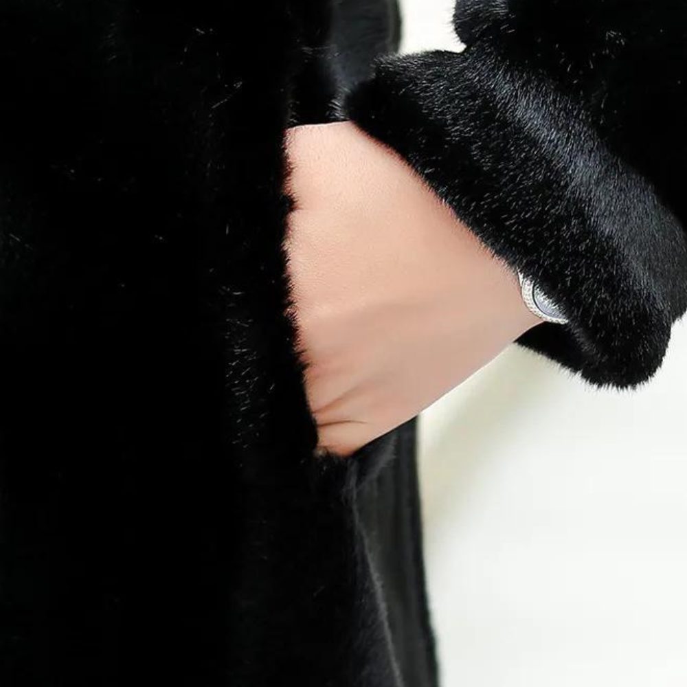 Close-up of side pocket and folded cuff on women's black faux-fur coat